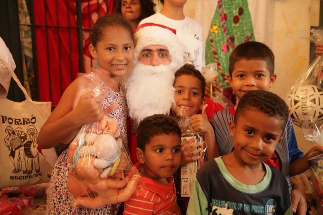 Ton Rodrigues vestido de Papai Noel junto com as crianças na entrega dos brinquedos da 1ª edição do Natalatte